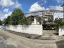 Residential house exterior with fenced yard and cloudy sky