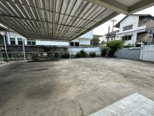 Spacious outdoor area with covered patio and concrete flooring