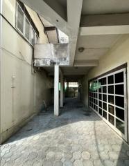 Paved outdoor area with covered passage and large windows