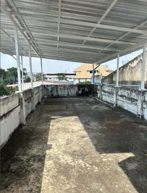 Spacious open-air rooftop area with metal roofing