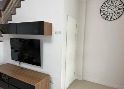 Modern living room with staircase and large wall clock
