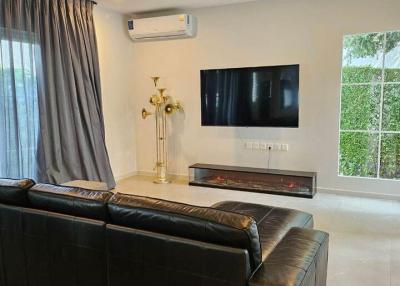 Modern living room with a large sofa and wall-mounted television