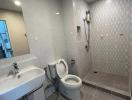 Modern bathroom with tiled floors and walls, and essential fixtures