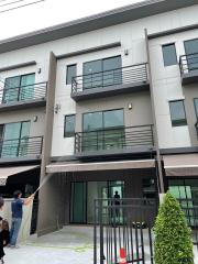 modern two-story residential building with a person cleaning