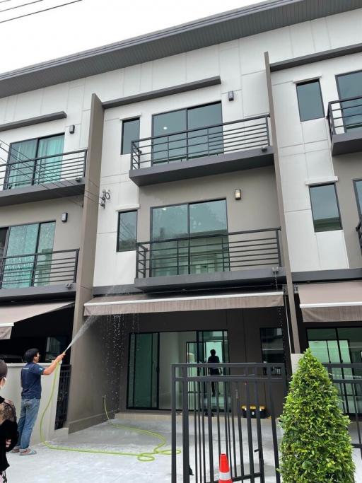 modern two-story residential building with a person cleaning