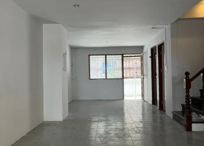Empty interior of a residential building with tiled flooring and staircase