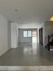 Empty interior of a residential building with tiled flooring and staircase