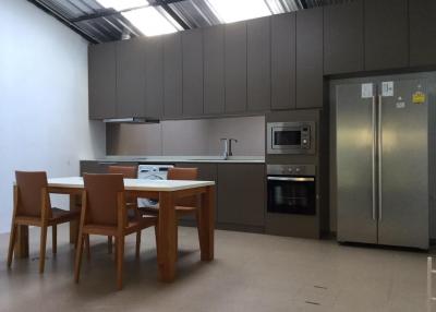 Modern kitchen with stainless steel appliances and wooden dining table