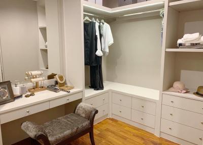 Elegant walk-in closet with built-in wardrobes and vanity area