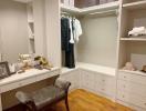 Elegant walk-in closet with built-in wardrobes and vanity area
