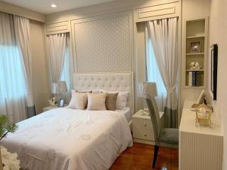 Elegant bedroom with white furnishings and hardwood floor