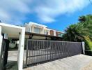 Modern two-story house with large driveway and gated entrance