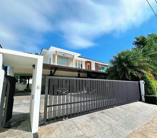 Modern two-story house with large driveway and gated entrance