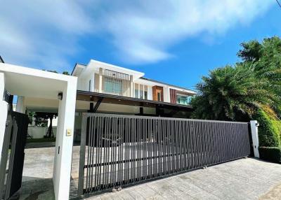 Modern two-story house with large driveway and gated entrance