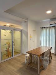 Bright and cozy dining area with a large wooden table and modern chairs