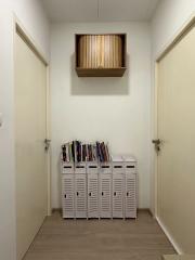 Bright and clean hallway interior with shoe storage and wooden shelving