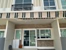 Exterior view of a modern residential townhouse with balcony and paved patio