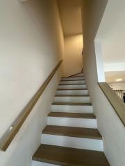 Interior view of a modern staircase with white walls and wooden steps