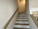 Interior view of a modern staircase with white walls and wooden steps