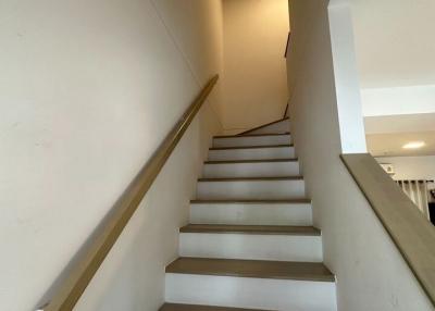 Interior view of a modern staircase with white walls and wooden steps