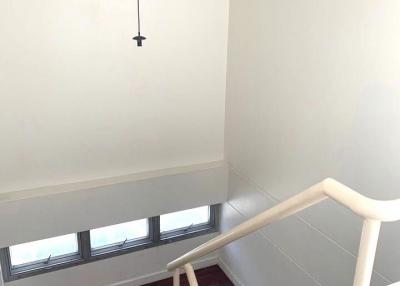 Bright staircase area with large windows and wooden floor