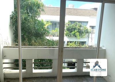 Sunny balcony with a view of neighboring buildings and greenery