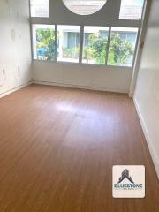 Empty bedroom interior with wooden flooring and large windows