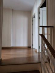 Spacious hallway with wooden flooring and staircase