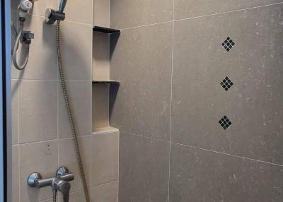 Modern bathroom with wall-mounted shower and built-in shelving