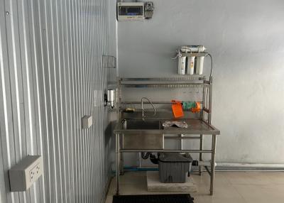 Commercial kitchen space with stainless steel sink and storage