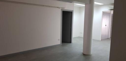 Spacious unfurnished interior of a building with white walls and pillars