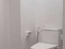 Modern white tiled bathroom with toilet