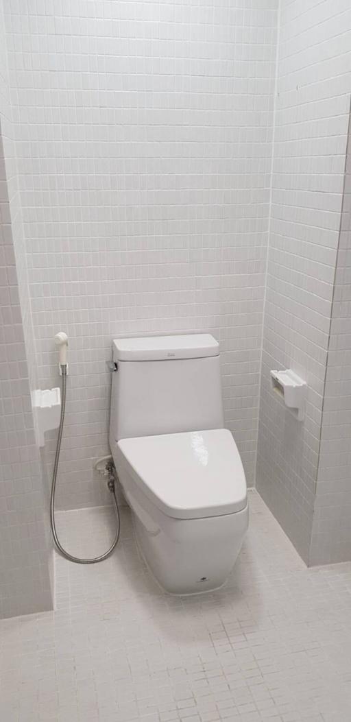 Modern white tiled bathroom with clean toilet