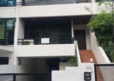 Exterior view of a modern multi-story residential building with balconies and air conditioning unit