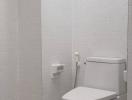 Modern white tiled bathroom with toilet