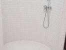 Curved corner shower with modern fixtures and mosaic tile walls