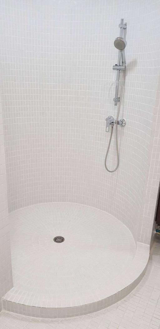 Curved corner shower with modern fixtures and mosaic tile walls