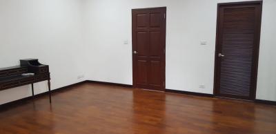 Spacious empty bedroom with hardwood floors and multiple doors