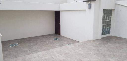 Spacious tiled courtyard with large windows and secure entrance