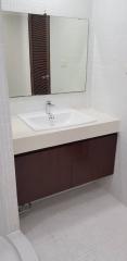 Clean contemporary bathroom with white tiles and wooden cabinet