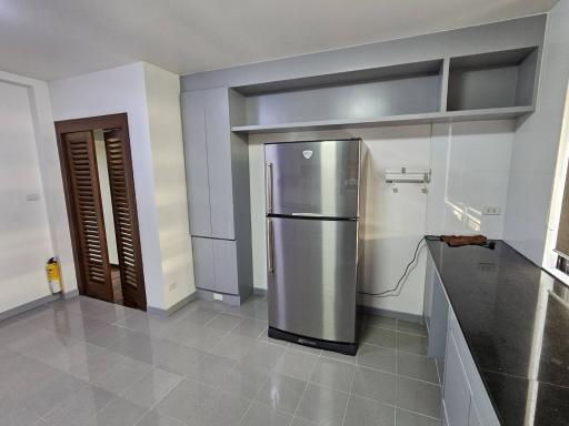 Modern kitchen with grey cabinetry and stainless steel refrigerator