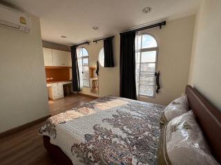 Spacious bedroom with natural light and adjoining open kitchen