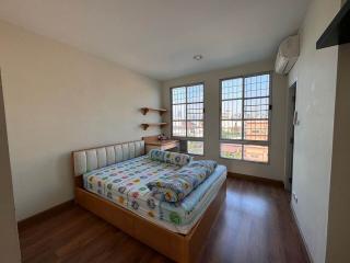 Spacious bedroom with natural light and air conditioning unit