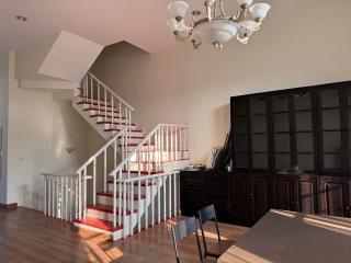 Spacious living room with staircase and elegant dark wood furniture