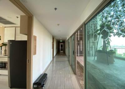 Spacious hallway with glass window wall overlooking exterior greenspace