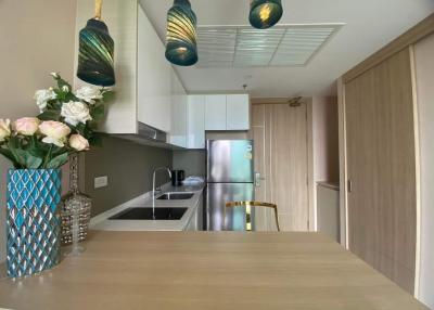 Modern kitchen interior with wood finishes and contemporary lighting