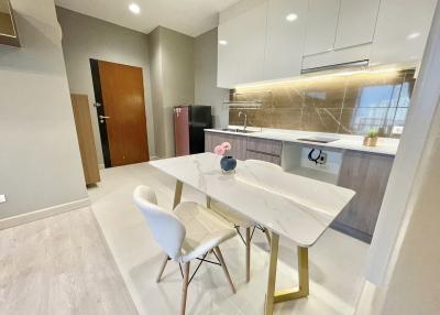 Modern kitchen with dining area, elegant finishes, and ample lighting
