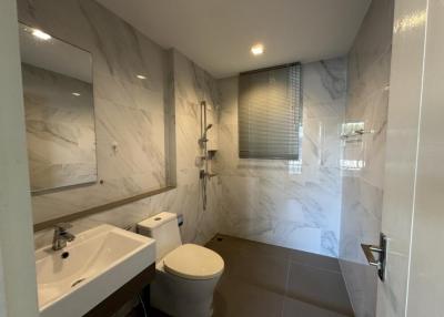 Modern bathroom with marble tiles and well-lit vanity area
