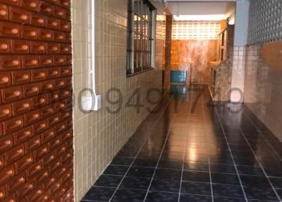 Tiled hallway with brick wall interior in residential building