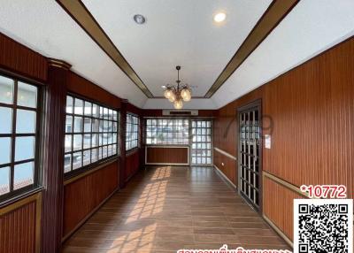 Spacious living room with large windows and wooden paneling